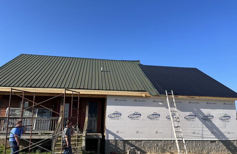 A new addition framed onto an existing house with a new metal roof