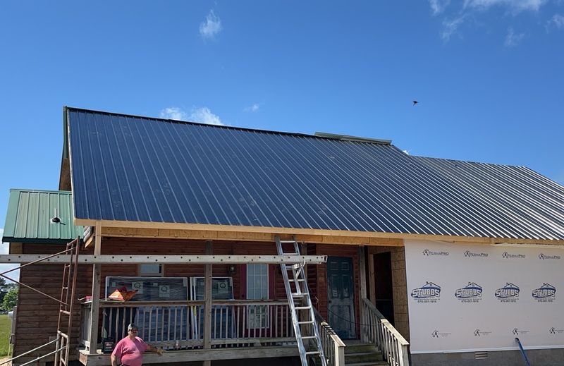 An addition tied into the original roofline, siding underway