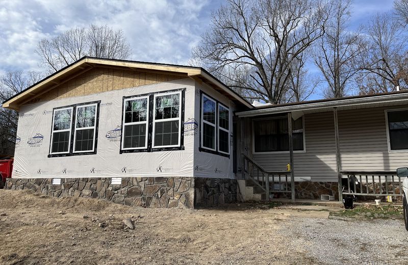 A remodelled home with new windows and a stone-faced skirt