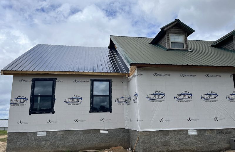An addition under housewrap with the new roof complete