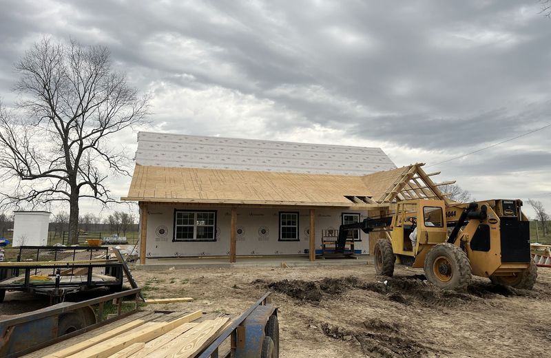 An addition framed and roofed alongside the original house