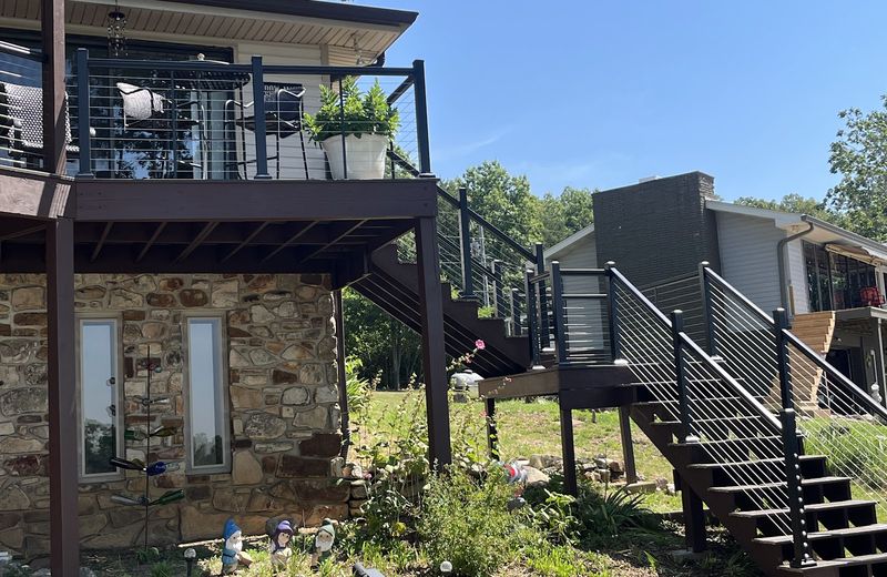 An elevated deck with black railing and a composite floor