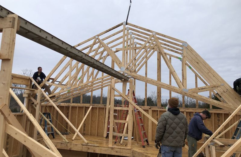 Two of the crew setting a roof truss by hand