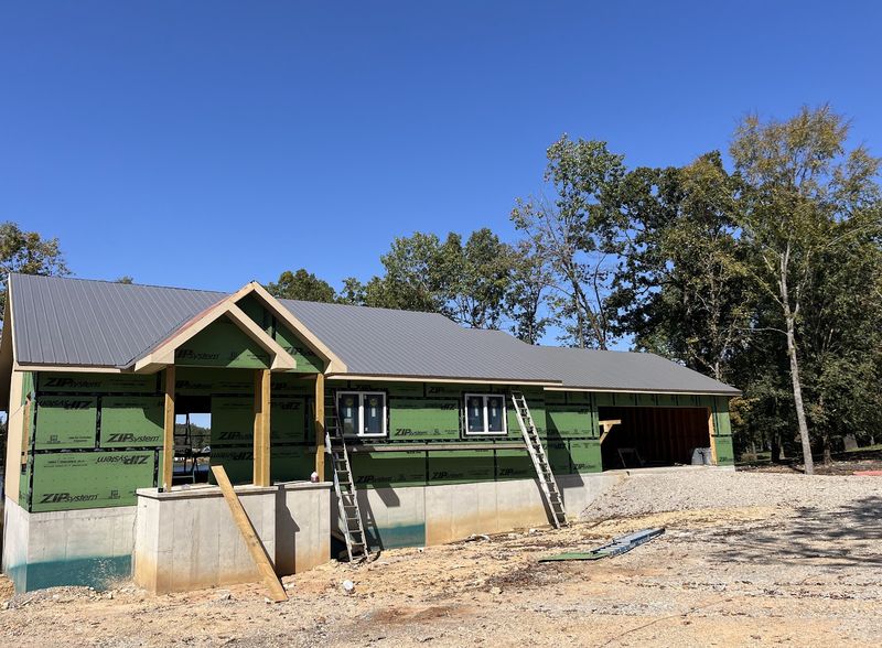 A finished home with a timber-post porch and metal roof