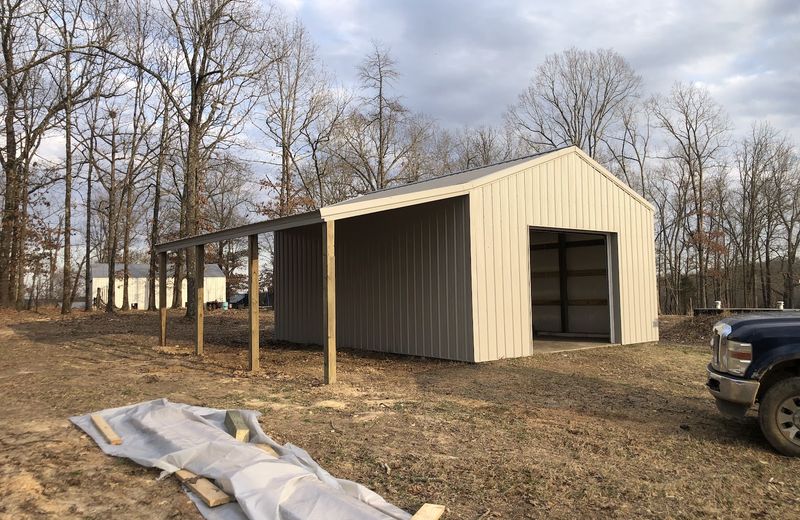 A finished metal shop with roll-up doors on a gravel pad