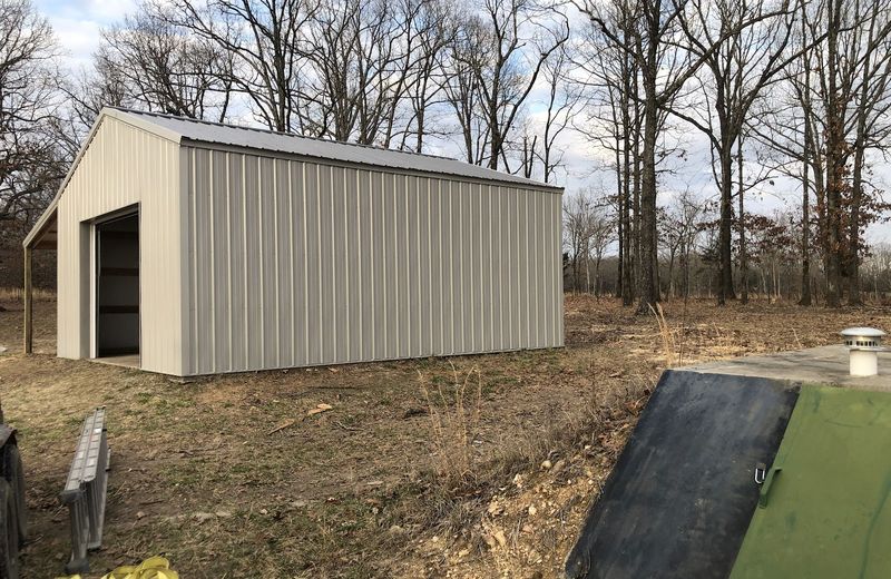 A finished grey metal shop on a sloped site