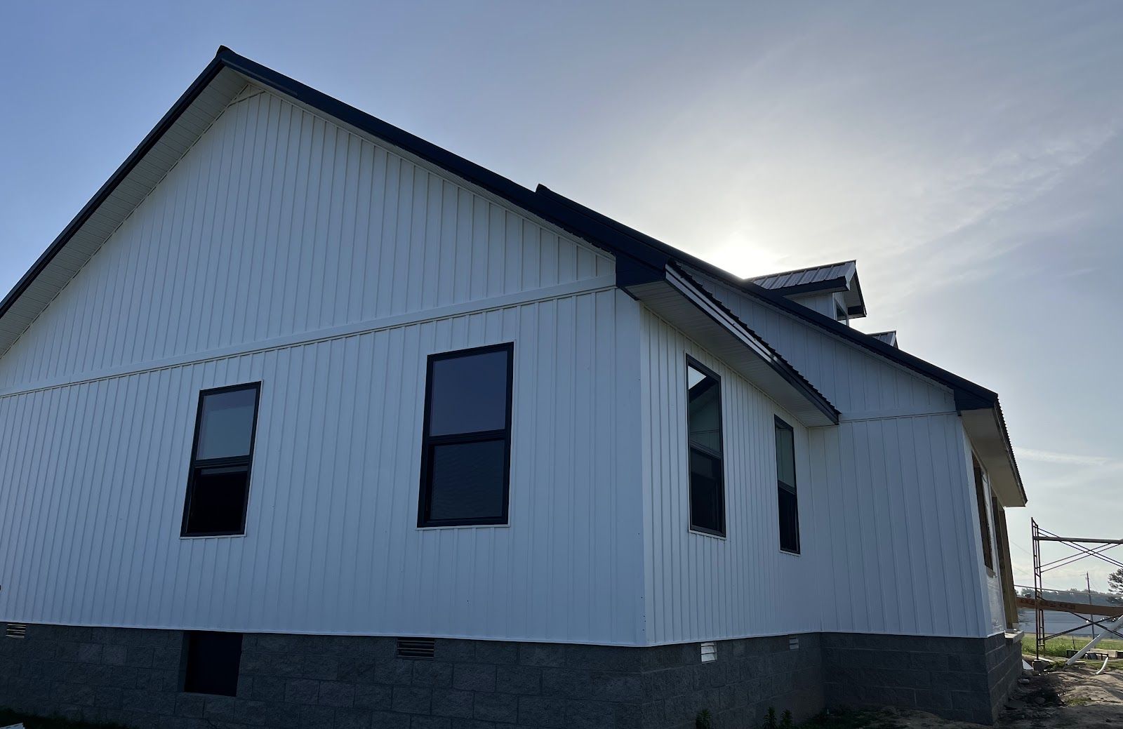 A finished home in white board-and-batten with a black metal roof